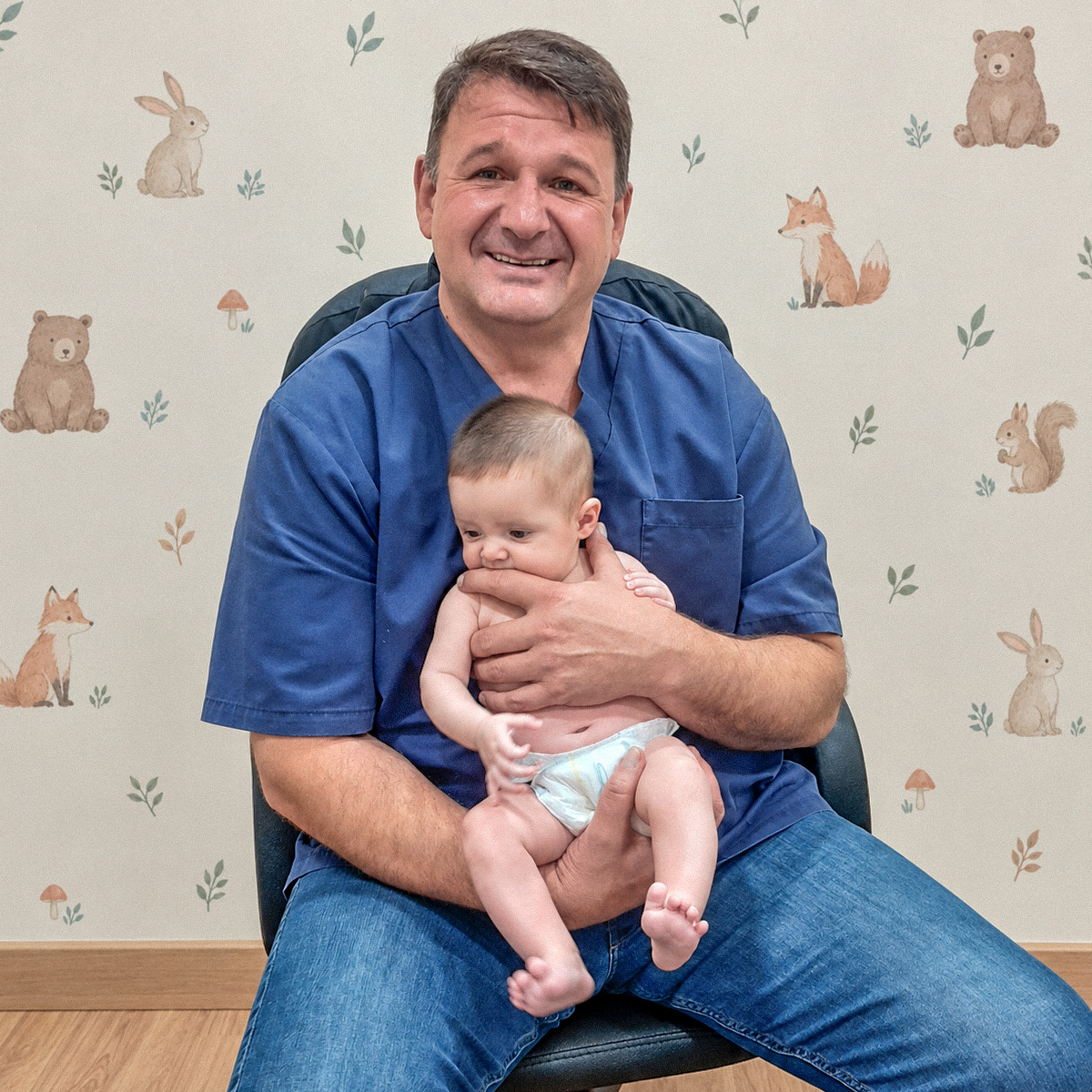 Dr. Yaroslav Martynyuk com um bebé ao colo na clínica